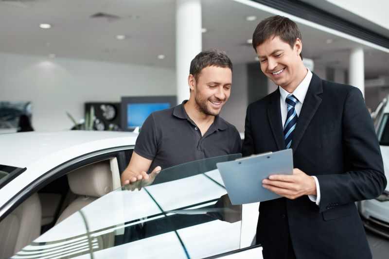 Car buyer reviewing extended warranty options with dealership representative