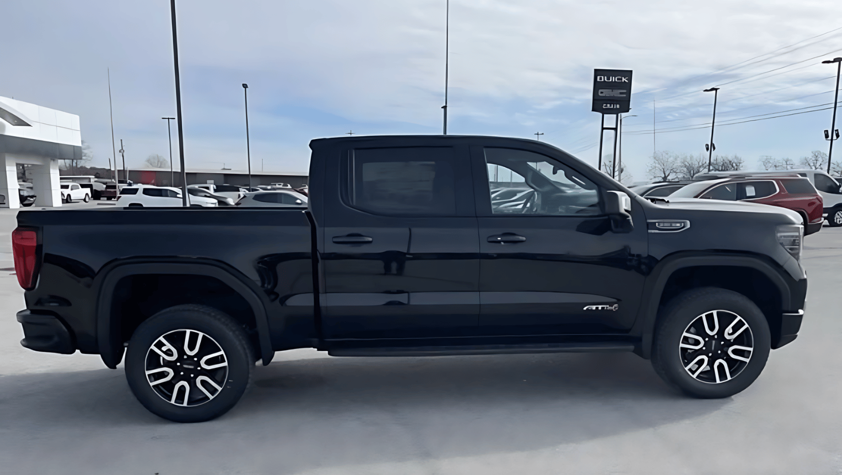 Side profile of a black 2025 GMC Sierra 1500 AT4 parked at Crain Buick GMC in Springdale, Arkansas