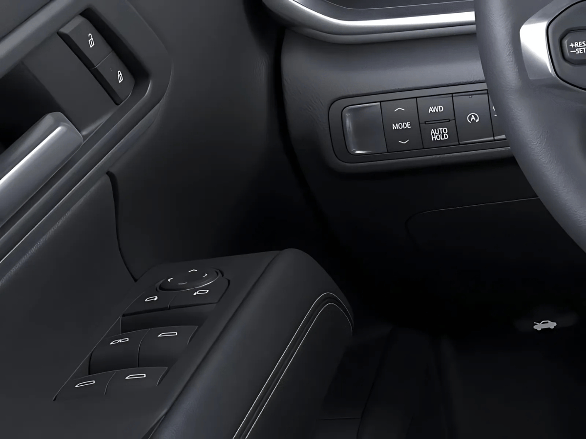 Close-up of 2025 GMC Terrain drive mode selector, AWD toggle, auto hold, and driver-side window controls