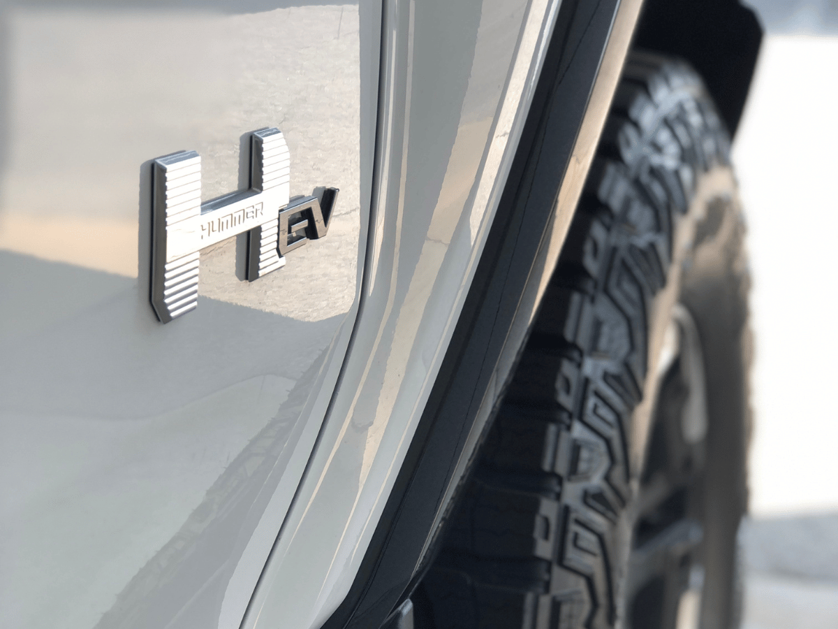 Detailed close-up of the 2026 GMC Hummer EV badge and rear tire, photographed at Crain Buick GMC in Springdale, Arkansas.