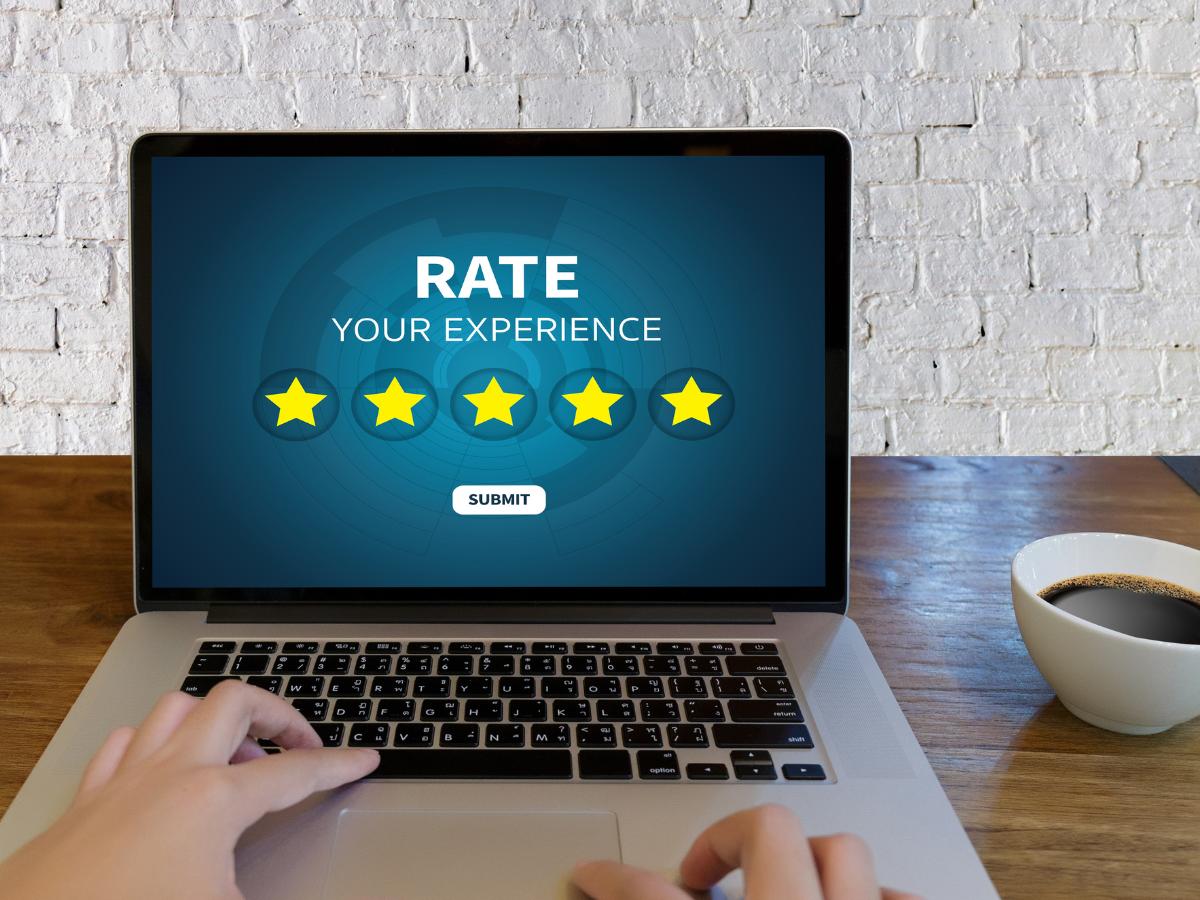 Person submitting a five-star service review on a laptop, reflecting positive customer experiences at Crain Buick GMC in Springdale.